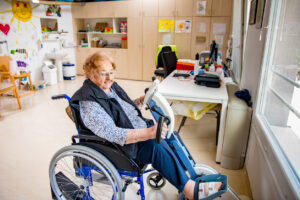 Oudere dame in rolstoel in revalidatiecentrum