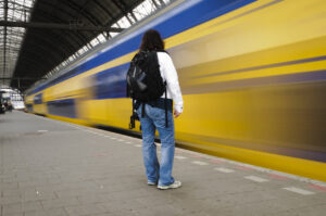 Trein rijdt met hoge snelheid voor passagier op het perron